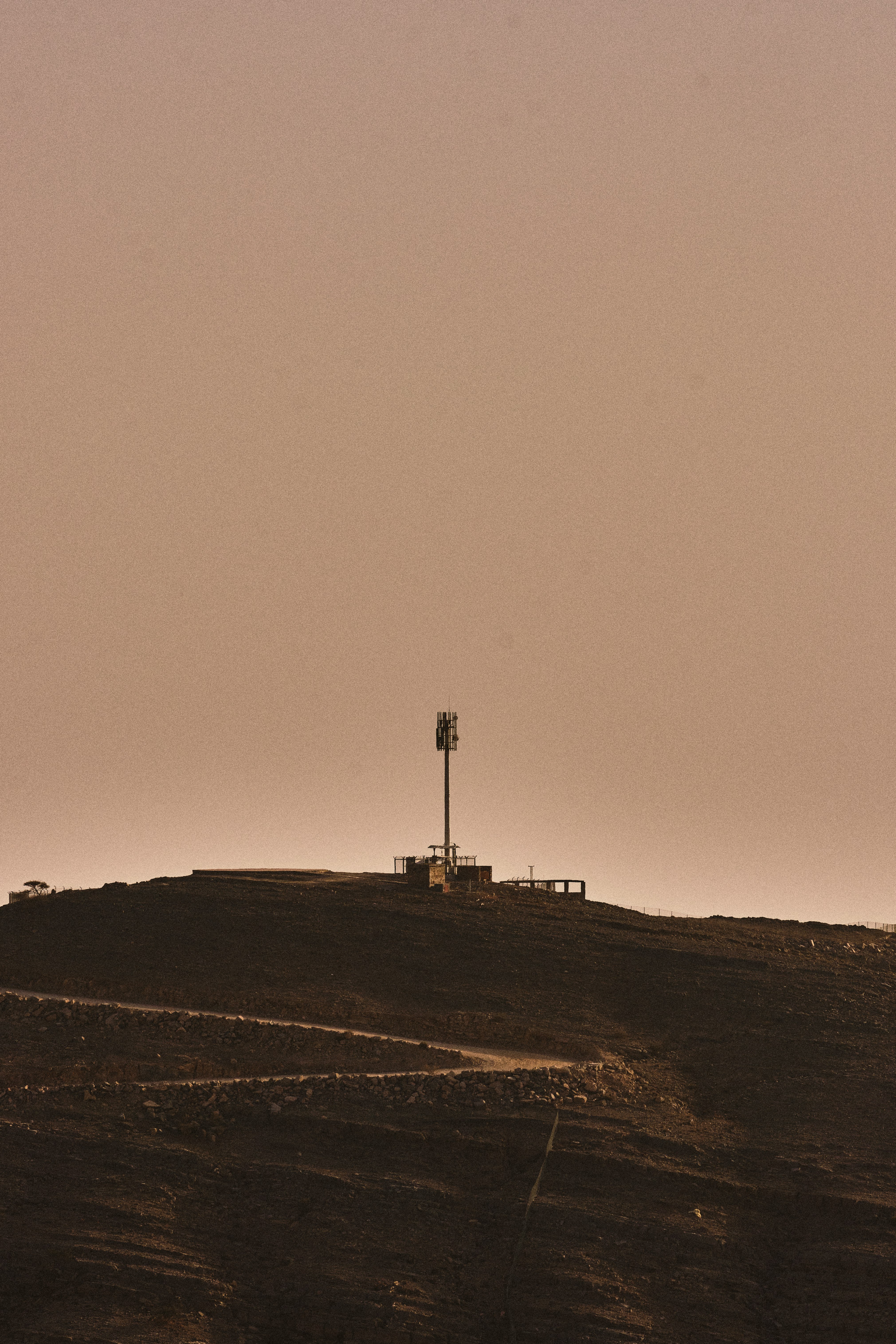 silhouette of person standing on hill during sunset